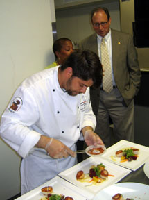 Photo of Fischbach and Secretary Fisher preparing scallops dishes