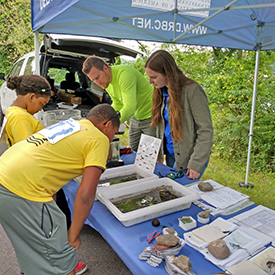 DRBC staff looks on as fishing derby participants check out our trays of aquatic critters. Photo by the DRBC.