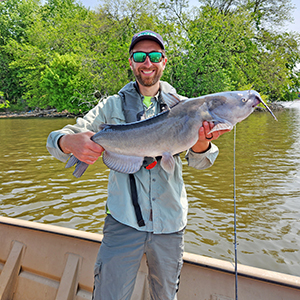 Staff holds a large catfish caught from the Delaware River. Photo by the DRBC.
