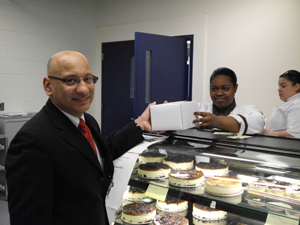 NJ State Board of Education President Arcelio Aponte buys cheesecake from the supermarket classroom at UCVTS. The fully function supermarket is open to the public and trains special education students for the workplace.