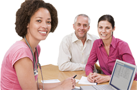 Doctor sitting with patients at laptop