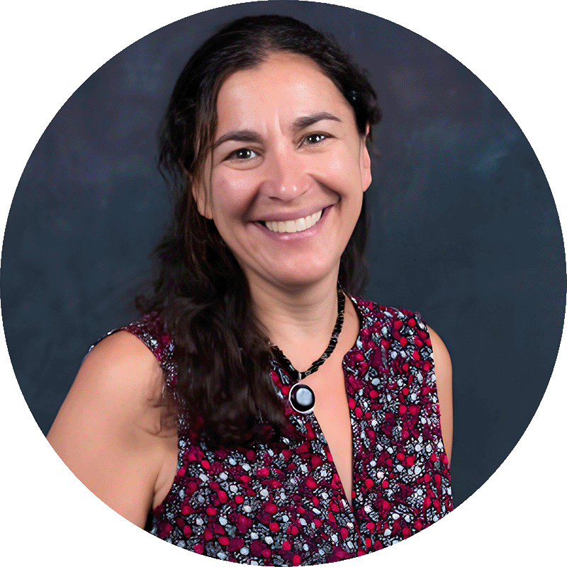 Headshot of Dr. Daniela Shebitz, professor at Kean University, with dark brown wavy hair passed her collarbone and a patterned purple sleeveless top.