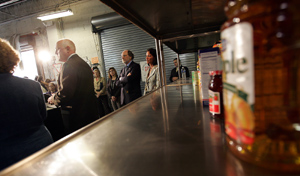 Photo of Governor Corzine and Secretary Kuperus in front of empty shelves at CUMAC