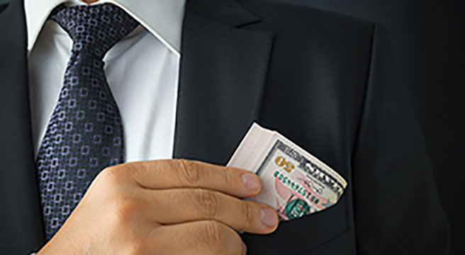 Photo: person putting money in chest pocket of suit coat