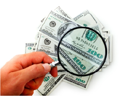 photo: S dollars and magnifying glass