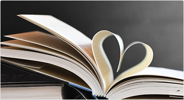 Photo of an open book with two pages curling to shape a heart