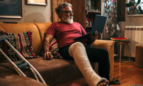 person sitting with a leg cast and crutch