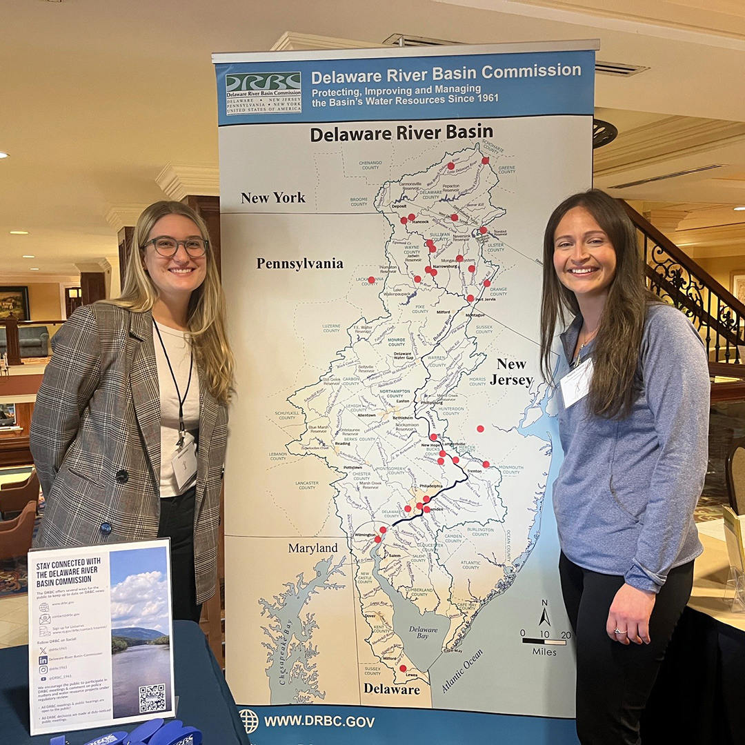 DRBC's Avery Lentini (L) & Trout Unlimited's Maddie Feaster pose for a photo by the DRBC's Basin Map. Photo by the DRBC.