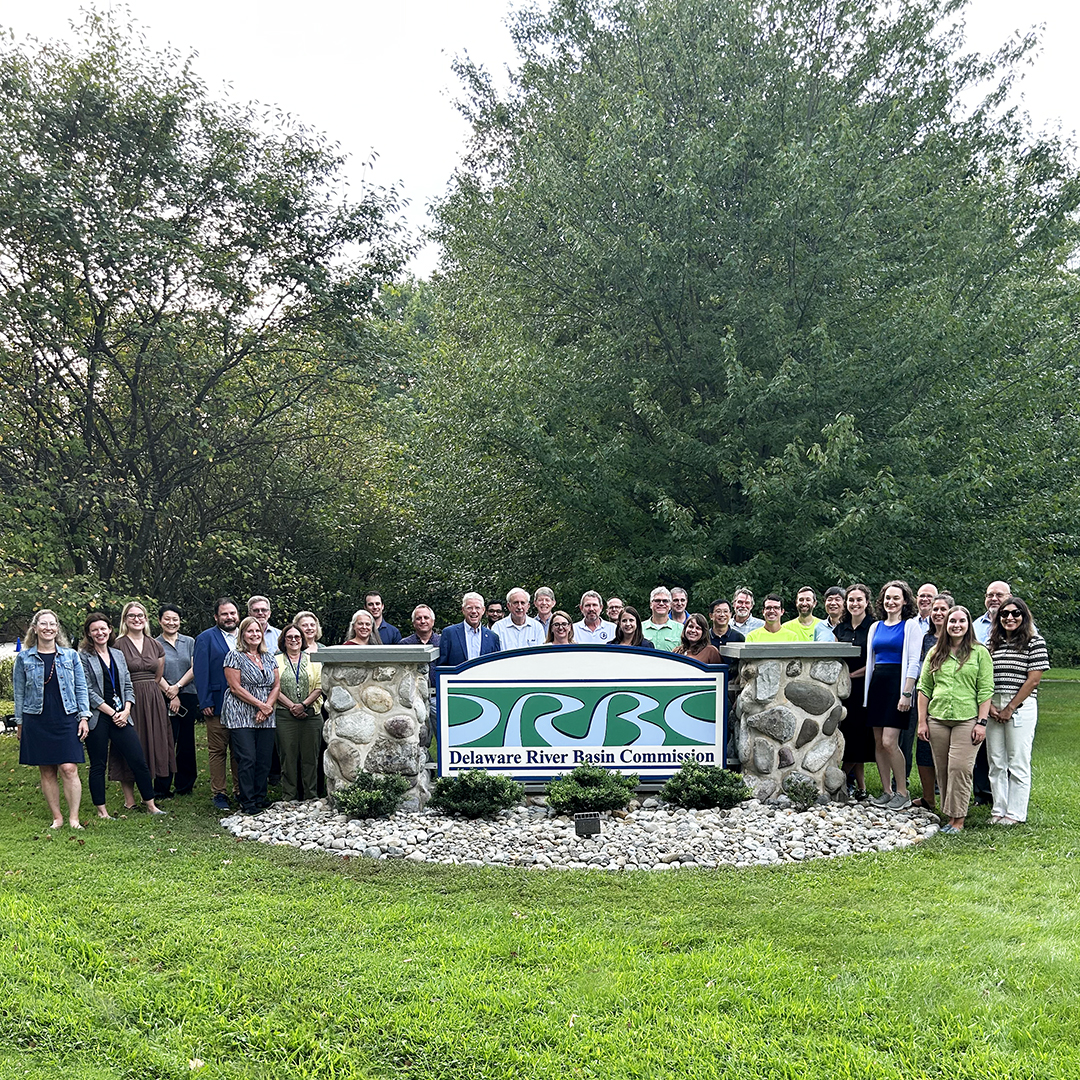 DRBC Commissioners and staff at the DRBC Building sign. Photo by the DRBC.