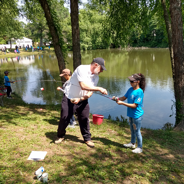An adult helping a youth prep a fishing rod. Photo courtesy of the DRBC.