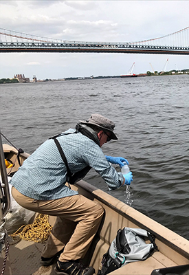 DRBC staff collects a surface water sample from the Delaware River to monitor for PFAS. Photo by DRBC.