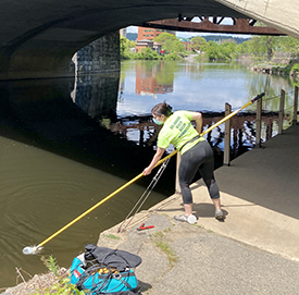 DRBC staff collect a water sample from the Lehigh River to monitor chlorides concentrations. Photo by DRBC.
