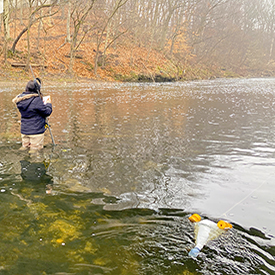 DRBC staff collects a flow measurement from the Neshaminy Creek during a sampling event for microplastics. Photo  by DRBC.