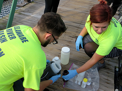 DRBC staff collect a water sample to monitor nutrient levels in the Delaware River. Photo by DRBC.