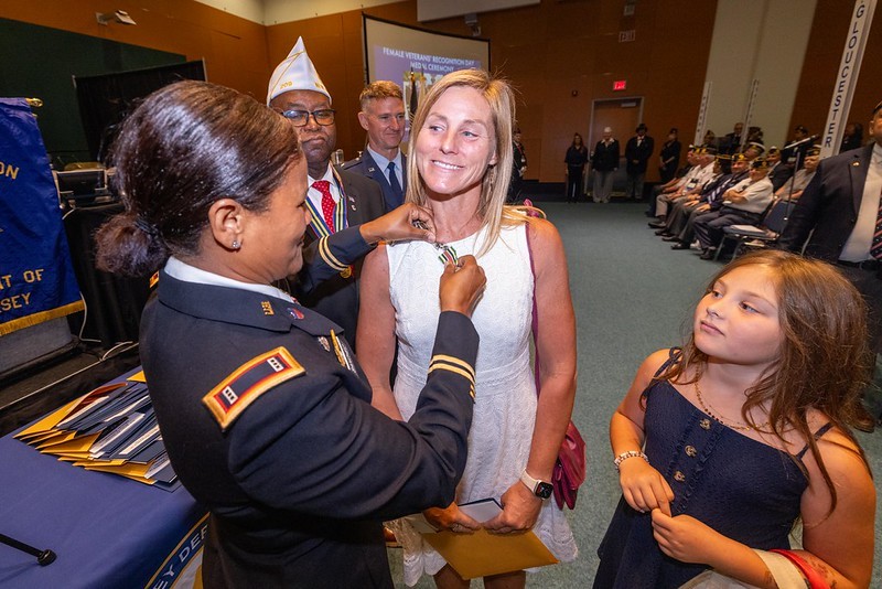 A woman veteran being presented a state service medal.