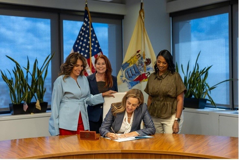 Governor Mikie Sherrill signing new law authorizing the creation of a specialty license plate in honor of the Borinqueneers.