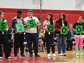 Students from Cinnaminson High School displaying the financial award at the Milken assembly.