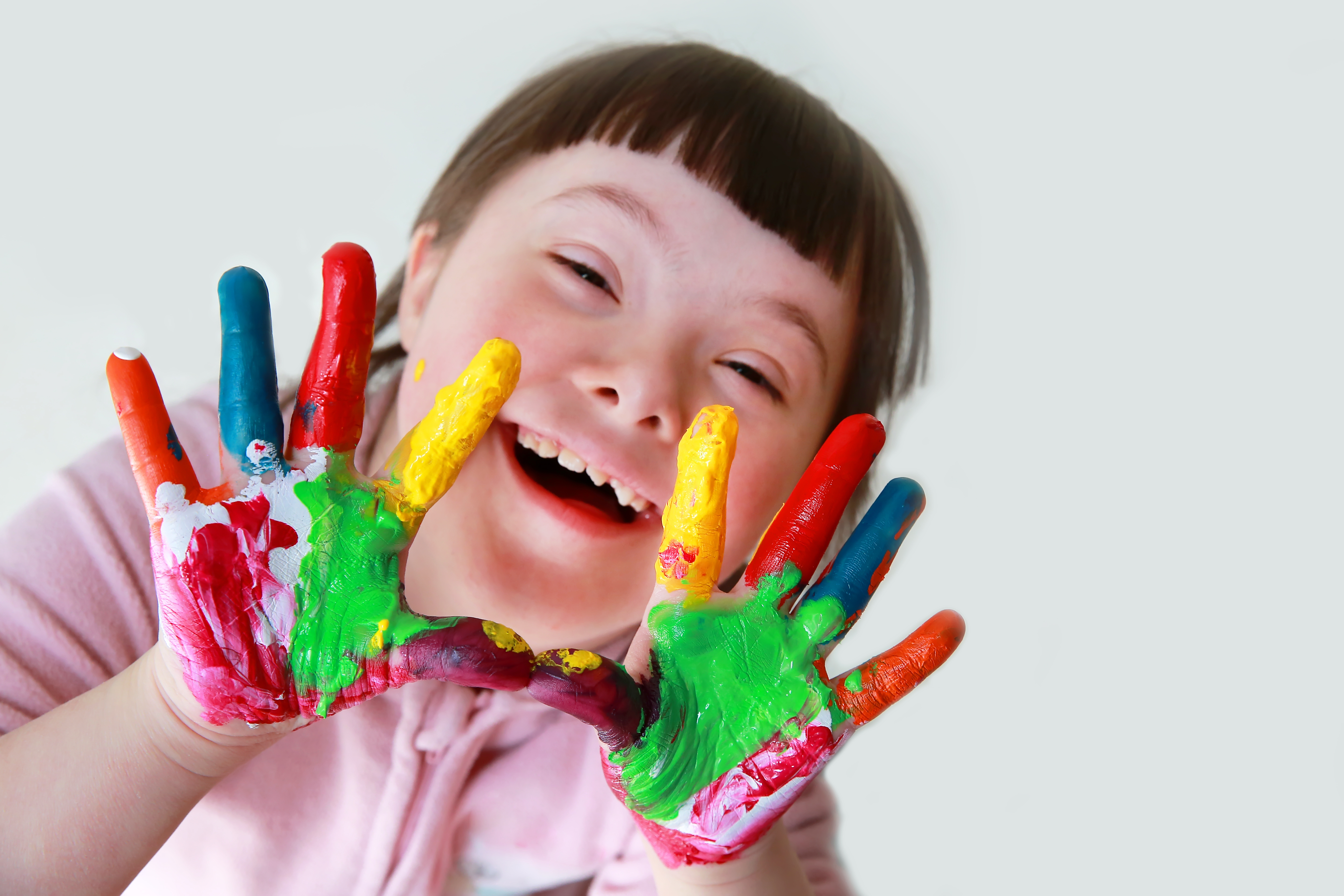 Student with disabilities smiling with finger paints