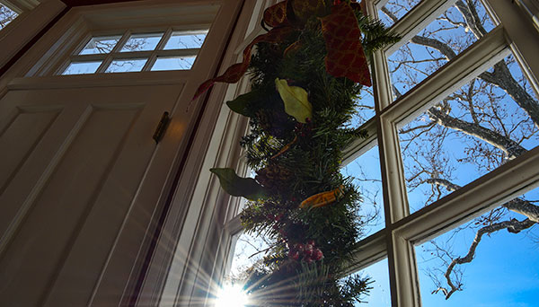 photo - A view of a vestibule window just outside the Governors Study. A natural arrangement hanging in the window, sunlight streaming through