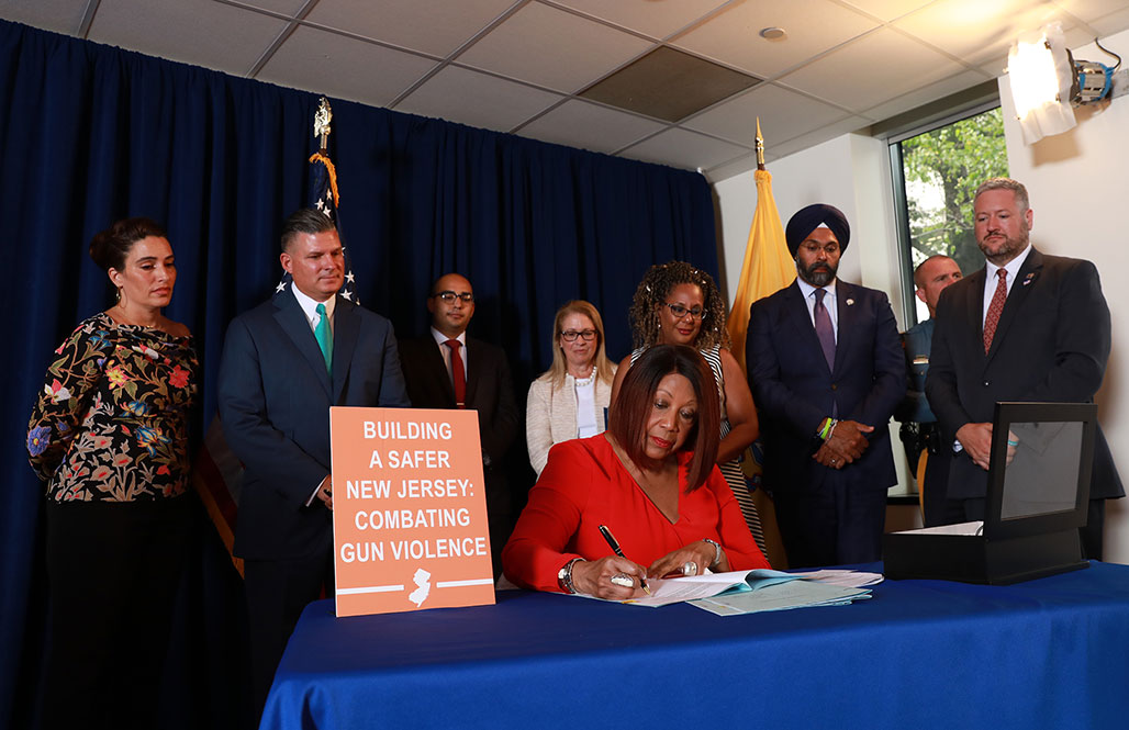 Acting Governor Sheila Oliver signing a package of gun violence intervention bills 