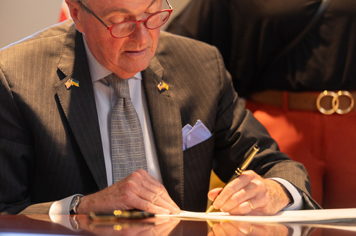 Governor Murphy sitting at a table signing