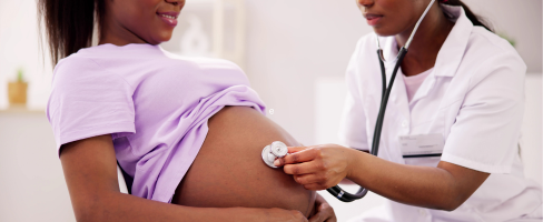 A doctor examining a pregnant person