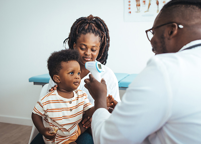 Doctor checking child for fever