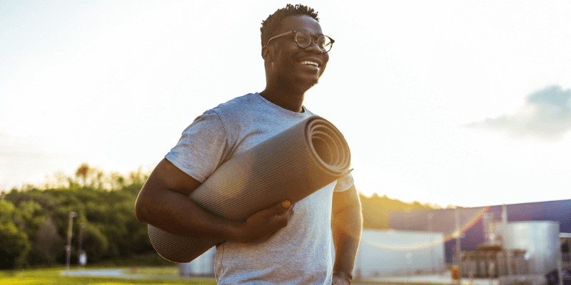 Man with a yoga mat in hand