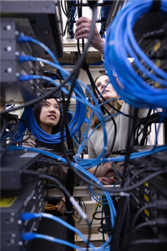 Asian female student working with a female instructor in an IT lab on a college campus
