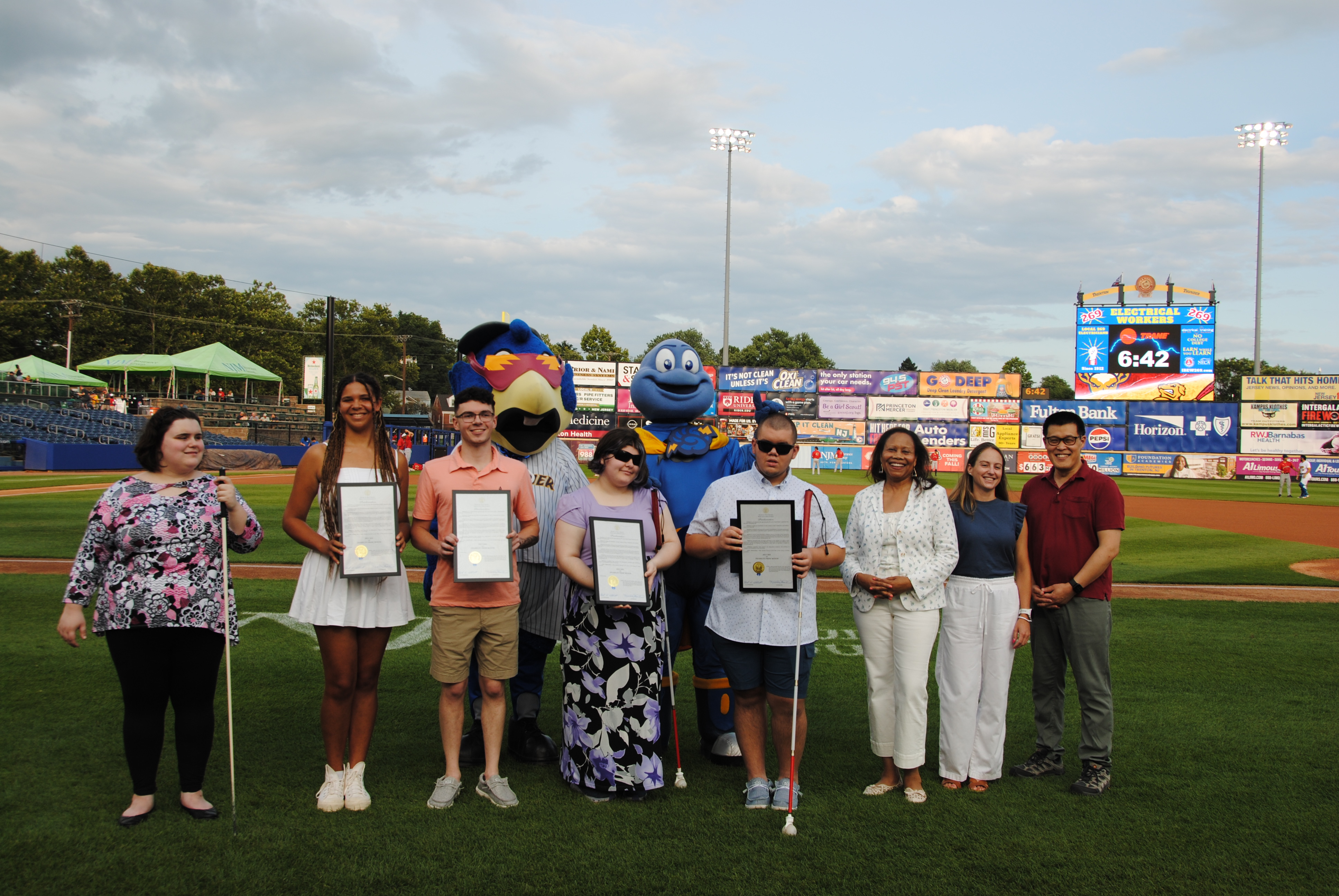 People posing for a picture with awards at the stadium