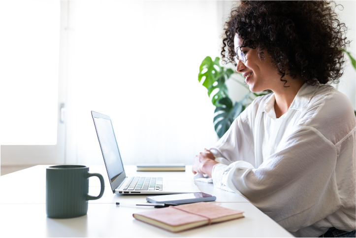 Woman is sitting by the table and working on the laptop