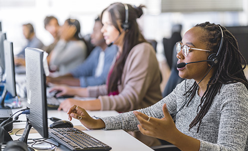 People working in call center on front of computers