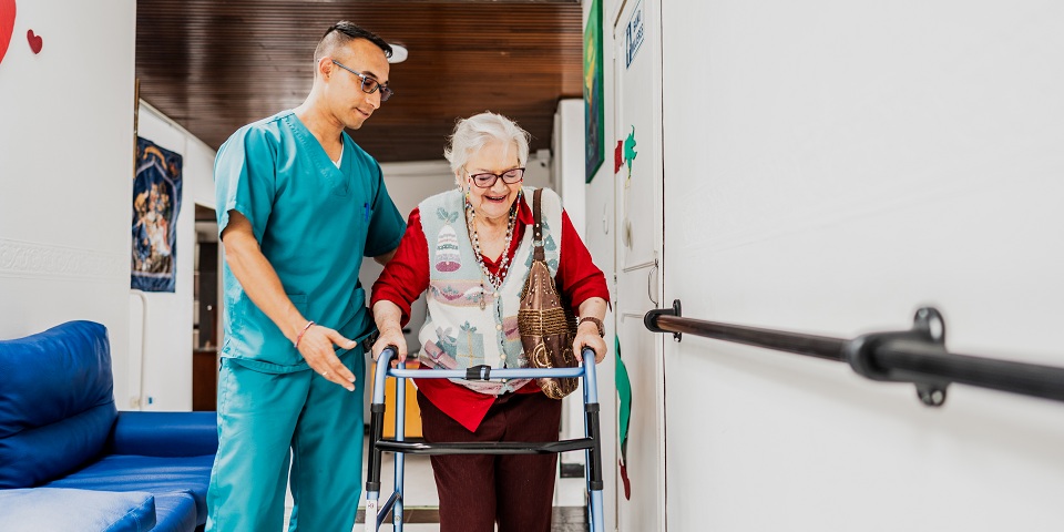Medical assistant helping woman with walker