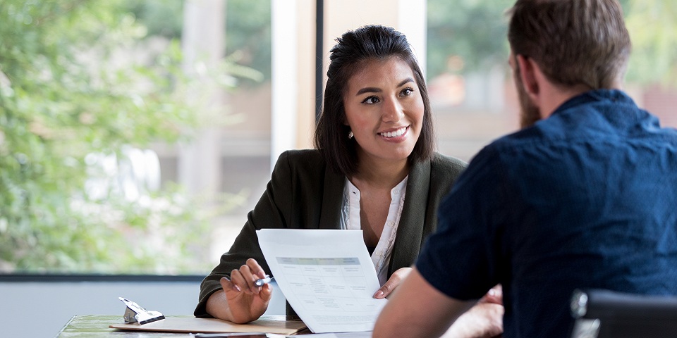 professional talking with someone at desk