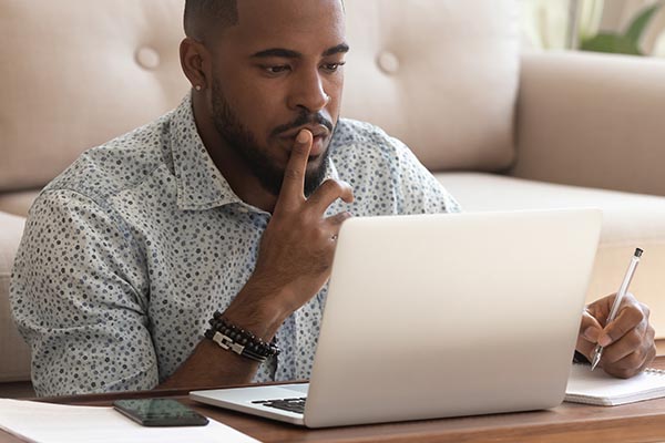 man thinking on laptop