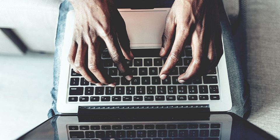 man's hands typing on a computer keyboard