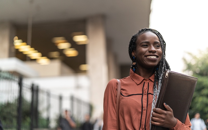 professional woman holding binder outside office building