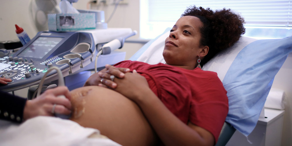 A pregnant woman getting an ultrasound at her healthcare provider's office