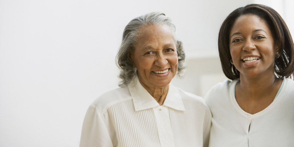 A woman and her mother, standing together, smiling