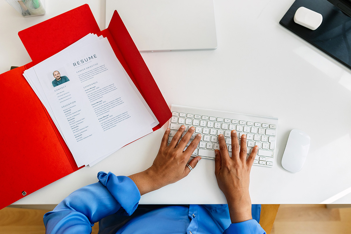 an overhead view of a recruiter's desk looking at a keyboard and printed resume