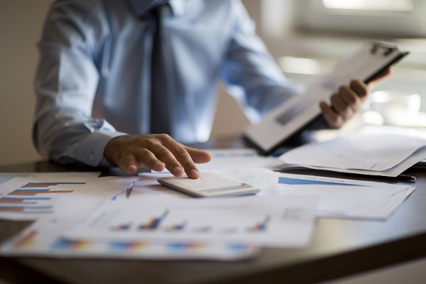 professional at desk covered with papers
