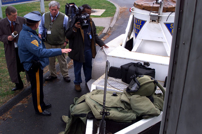 Detective I Robert Karmazin of the Arson/Bomb Unit displays a protective suit and blast container