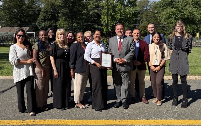 Commissioner Vincent Solomeno, Noelle Lee-Turner, and fellow DVA employees pose with letter from Governor Mikie Sherrill.