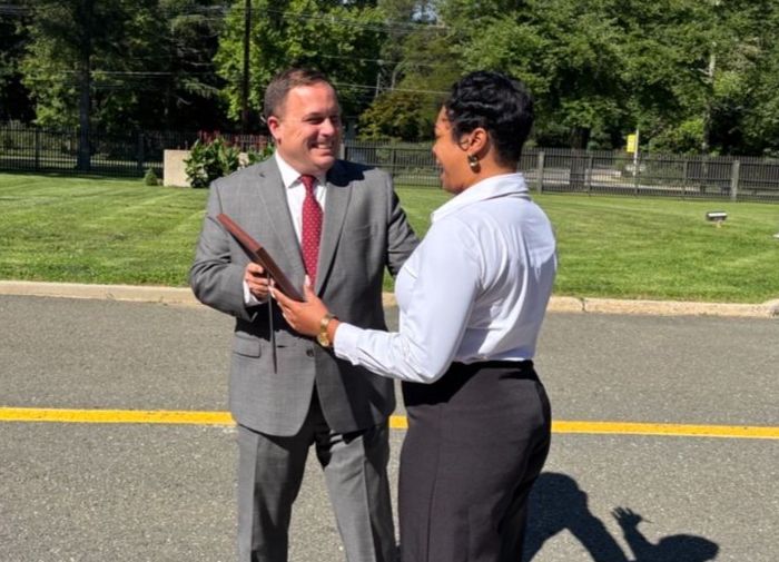 Commissioner Vincent Solomeno presents Noelle Lee-Turner with letter of commendation from Governor Mikie Sherrill