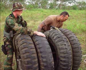1st Lt. Joseph Rougneen and Sgt. Fred Derry prepare sling load of truck tires for the flight to Yaviza.