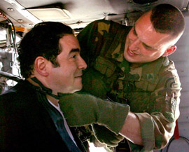 Blackhawk crewchief Sgt. Eric Chambers (right) straps in Emeril Lagasse

        (left) prior to taking off. Photo by Tech. Sgt. Mark Olsen, NJDMAVA/PAO.