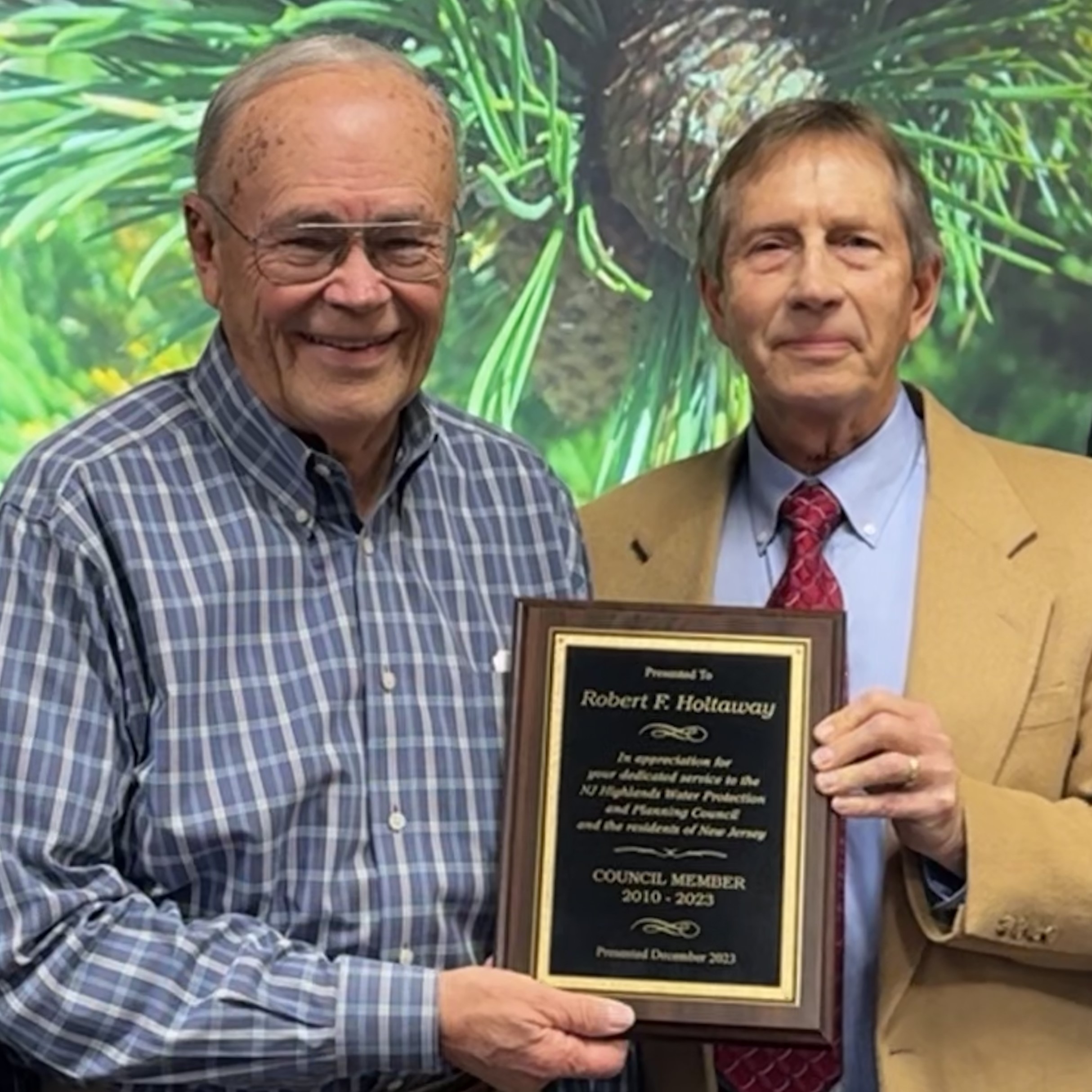 two men holding a plaque
