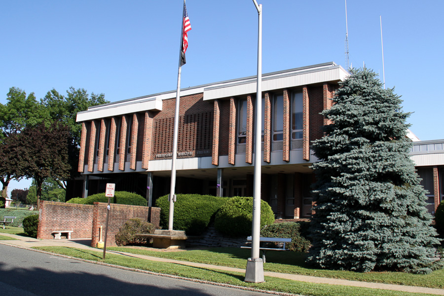 brick municipal building with flag in front