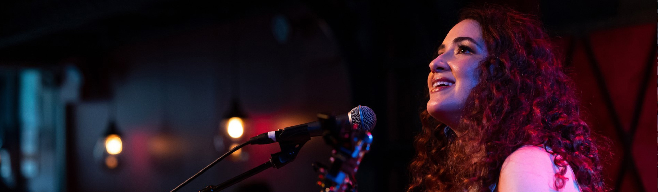 an artist singing and playing guitar on stage
