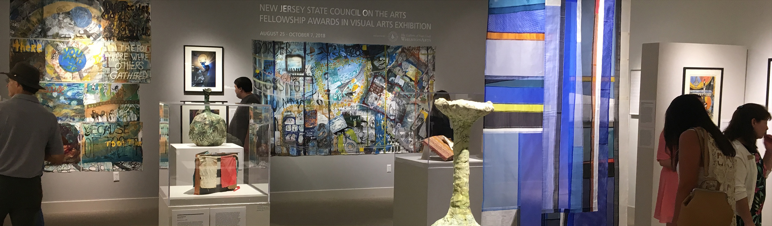 a colorful, abstract wooden sculpture in an art gallery